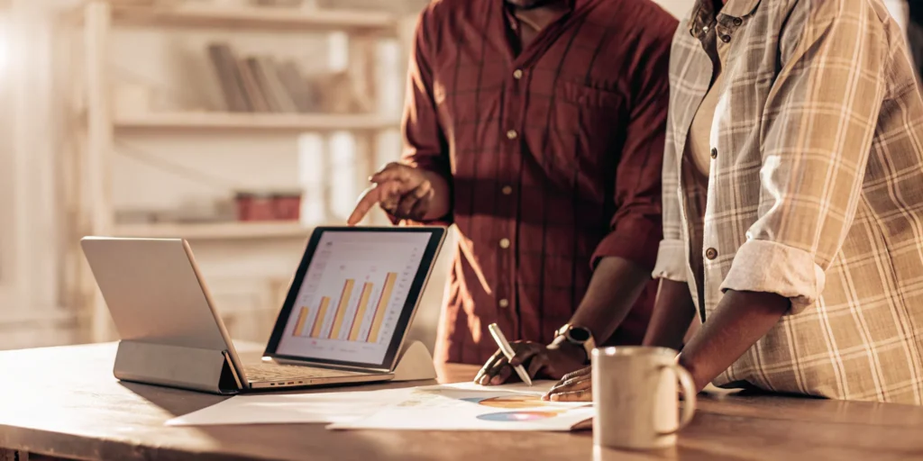 An accountant for a small business reviews financial charts with a founder on a laptop.